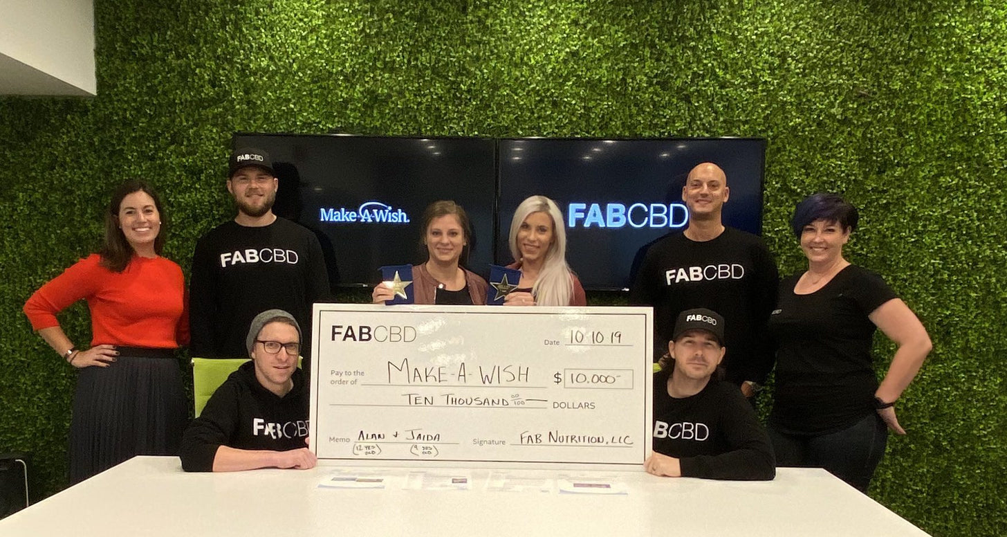 The FAB team holds up an oversized check to the Make-A-Wish Foundation for $10,000.