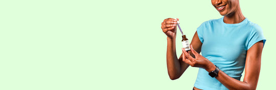 woman holding a bottle and dropper of fab cbd oil