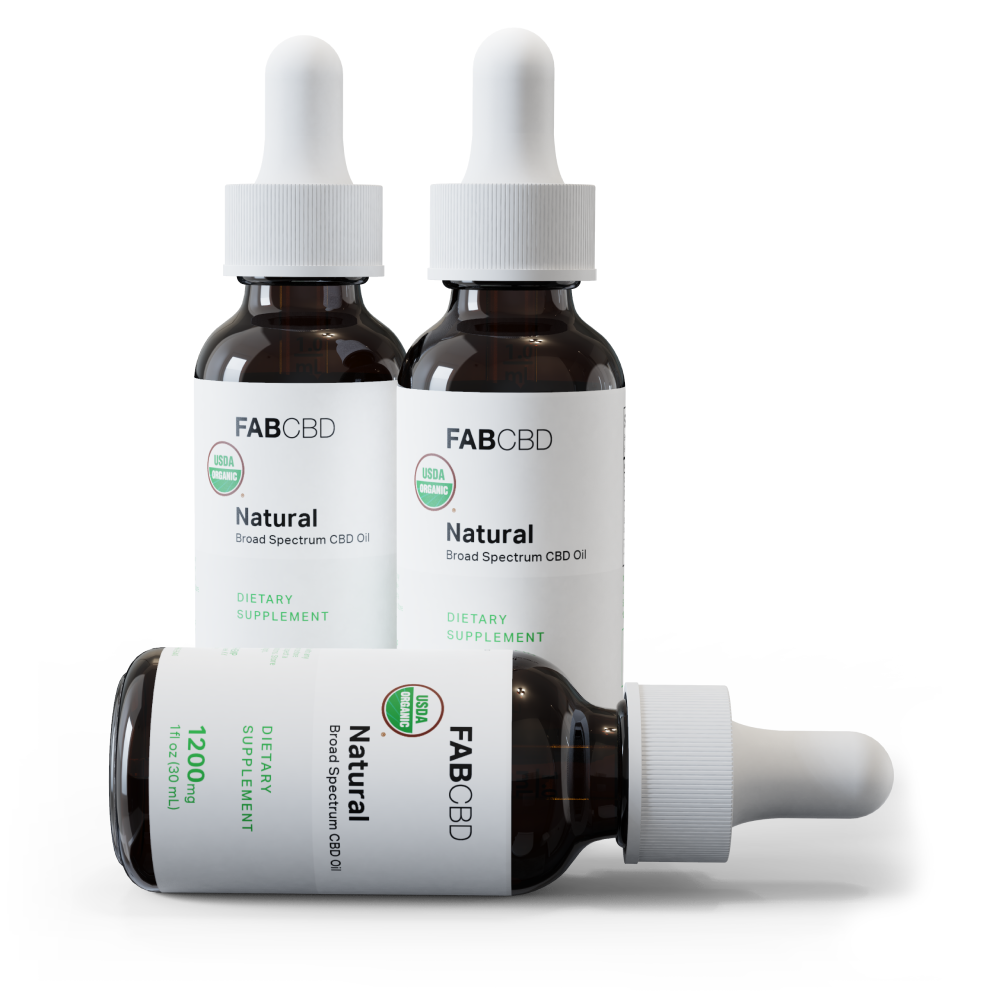 Three-bottle studio shot of Broad Spectrum CBD Oil - 3-Pack Bundle with two upright amber dropper bottles and one lying in front on a white background