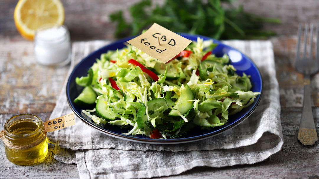 A bowl of healthy foods on a wooden table with eggs and avocado nearby