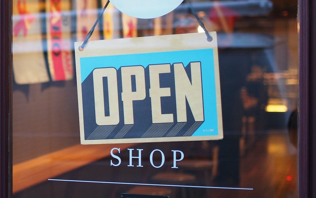 A sign on a store door says "open"