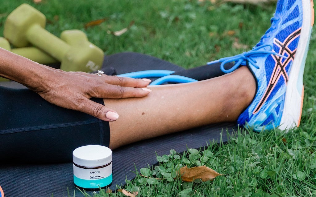 woman applying cbd topical to her legs