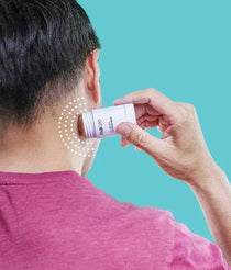 Man applying a FAB CBD roll-on stick to the back of their neck against a teal background