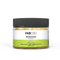 Front-facing shot of a clear jar of Delta 9 Gummies by FABCBD with a ribbed black lid, visible yellow sugar-coated gummies and a green-and-white label.