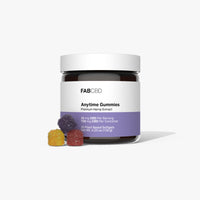 Centered front view of a jar labeled FABCBD Anytime Gummies with a white lid, purple lower label and three colorful sugar-coated gummies at its base