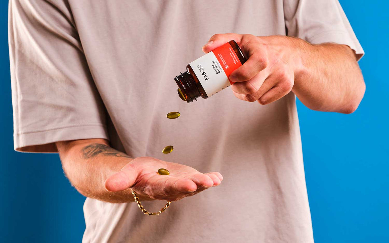man pouring cbd capsules into his hand