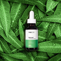 Centered front view of the FABCBD CBD Oil dropper bottle against dewy green leaves.