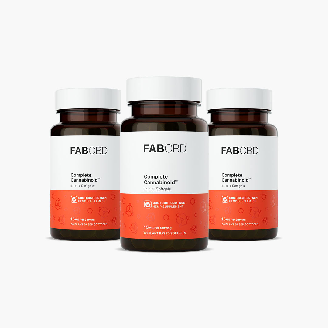 Three amber glass supplement bottles with white caps arranged in a tight cluster, with one bottle slightly in front of the other two, against a pure white background. Each bottle features FAB CBD branding for Complete Cannabinoid™ 1:1:1:1 Softgels and displays identical product specifications on its white and bright orange label: "CBC+CBG+CBD+CBN HEMP SUPPLEMENT," a potency of "15MG Per Serving," and a total count of "60 PLANT BASED SOFTGELS."