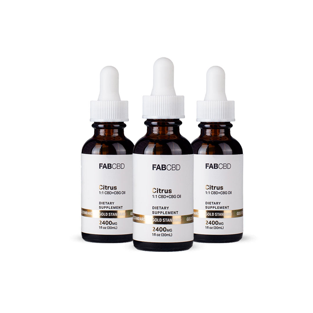 Three amber dropper bottles of FAB CBD Citrus 1:1 CBD+CBG Oil dietary supplement standing side by side in a row. Each bottle features a white label with a gold "Gold Standard" banner displaying product specifications, including a potency of 2400MG and a volume of 1 fl oz (30mL), set against a pure white background.