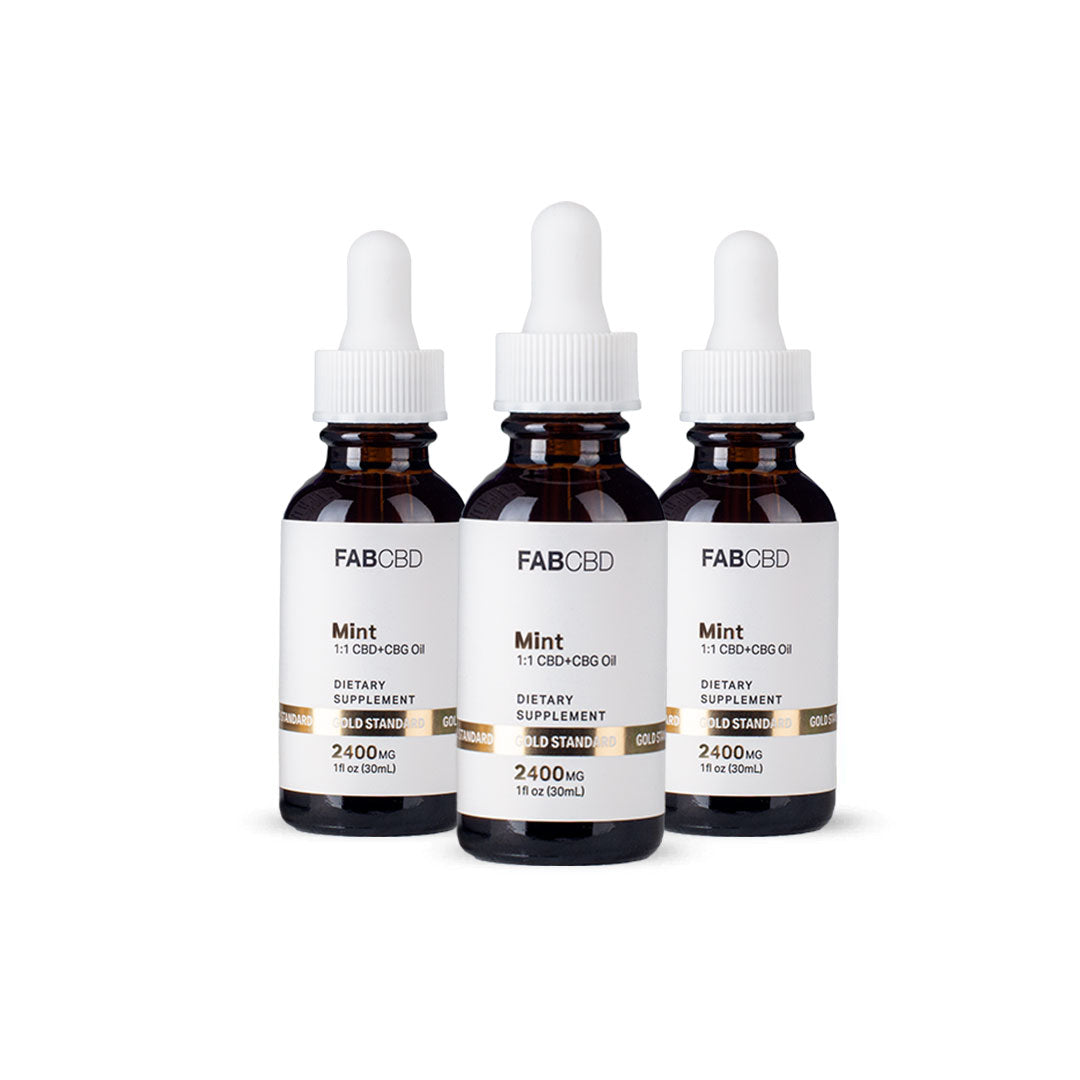 Three amber dropper bottles of FAB CBD Mint 1:1 CBD+CBG Oil dietary supplement standing side by side in a row. Each bottle features a white label with a gold "Gold Standard" banner displaying product specifications, including a potency of 2400MG and a volume of 1 fl oz (30mL), set against a pure white background.