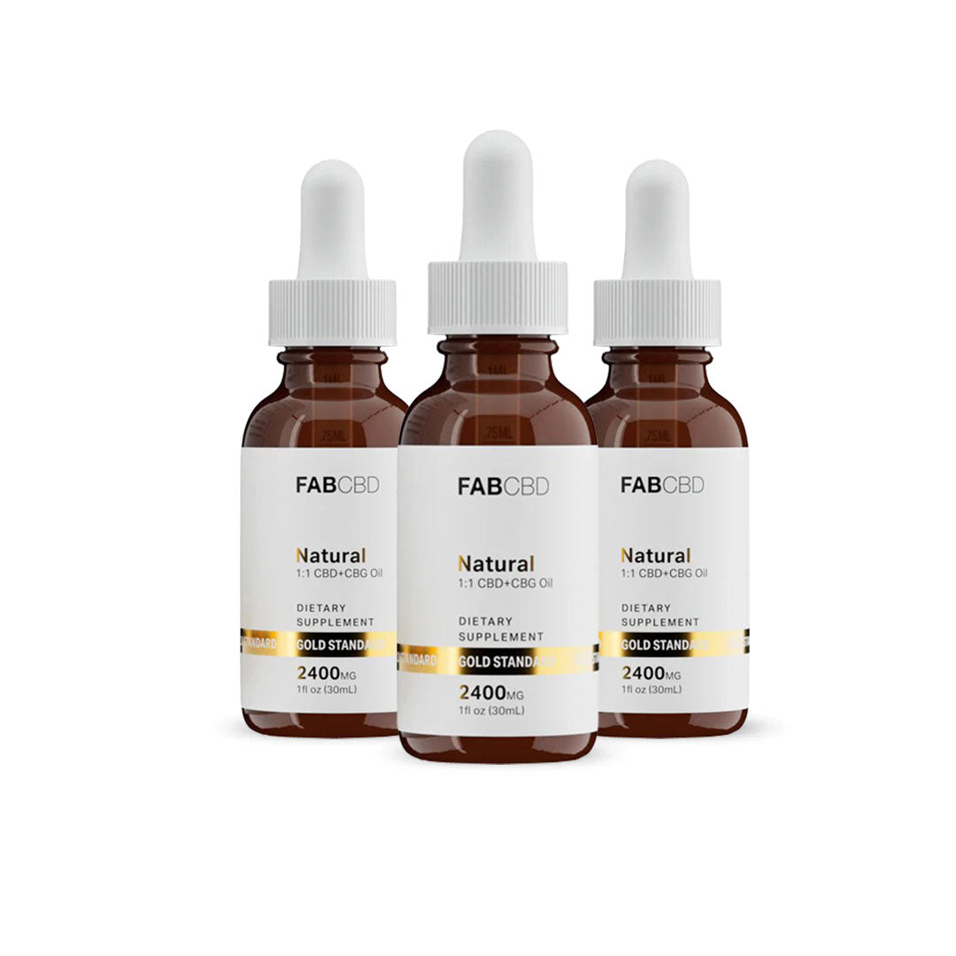 Three amber dropper bottles of FAB CBD Natural 1:1 CBD+CBG Oil dietary supplement standing side by side in a row. Each bottle features a white label with a gold "Gold Standard" banner displaying product specifications, including a potency of 2400MG and a volume of 1 fl oz (30mL), set against a pure white background.
