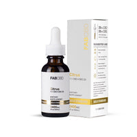 An amber dropper bottle of FAB CBD Citrus 1:1 CBD+CBG Oil standing directly next to its white outer packaging box. The bottle label displays the product specifications "2400MG" and "1 fl oz (30mL)" below a shiny gold "Gold Standard" banner. The visible side panel of the white box details additional specifications, including "20MG CBD" and "20MG CBG" per serving (0.5mL or 1/2 dropper), a matching gold "Gold Standard" band at the bottom, an illustrated dropper icon, and a structured "Suggested Use" guide with