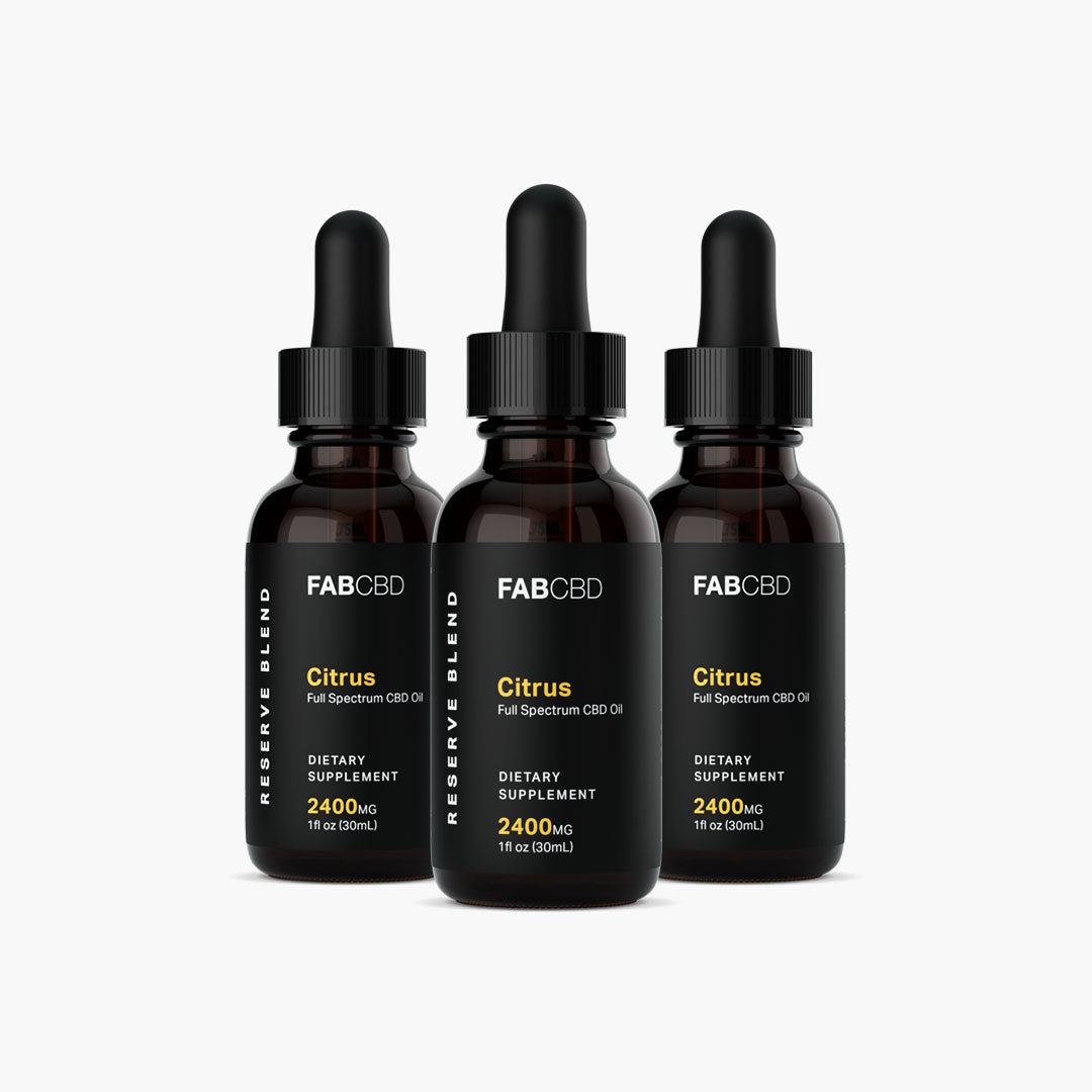Front-facing trio of FABCBD CBD Oil amber dropper bottles with black labels and pipette caps arranged against a white background.