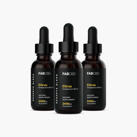 Front-facing trio of FABCBD CBD Oil amber dropper bottles with black labels and pipette caps arranged against a white background.