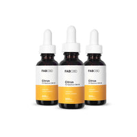 Front view of three FABCBD CBD Oil dropper bottles with white labels and citrus-orange panels arranged in a slight arc on a white background.