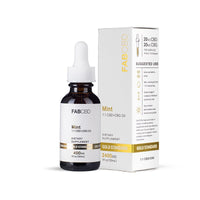 A crisp product photograph showing an amber dropper bottle of FAB CBD Mint 1:1 CBD+CBG Oil standing beside its white cardboard packaging box. The bottle features a clean white label with a reflective gold "Gold Standard" band displaying "2400MG" and "1 fl oz (30mL)". The side of the outer box clearly displays serving details-specifying "20MG CBD / 20MG CBG PER SERVING (0.5mL) 1/2 Dropper"-along with icons and text detailing a structured "Suggested Use" guide, all set against a pure white background.