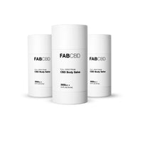 Front three-quarter view of three white FABCBD CBD Body Salve sticks with bold black text on a bright white background.